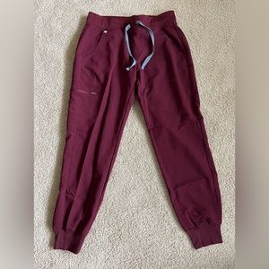 Maroon FIGS scrub pants.